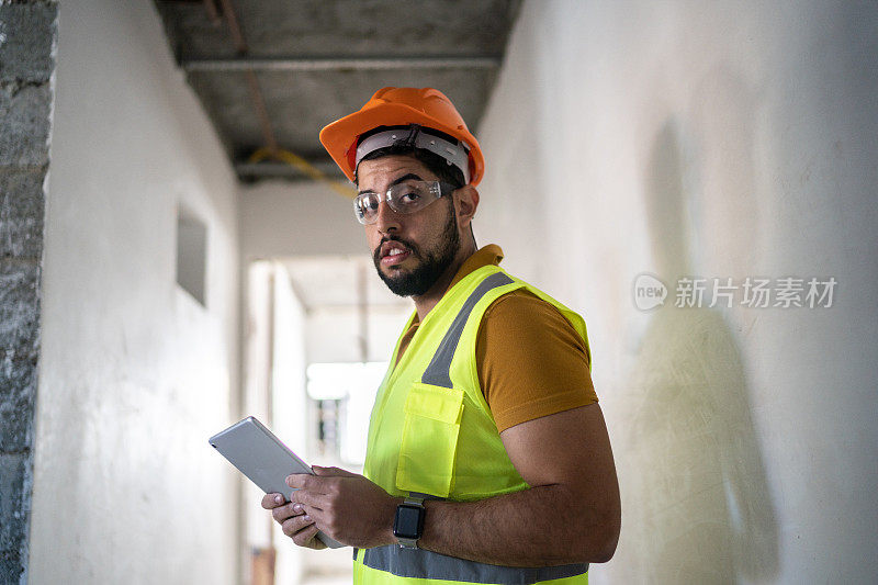 一名工程师在建筑工地使用数码平板电脑