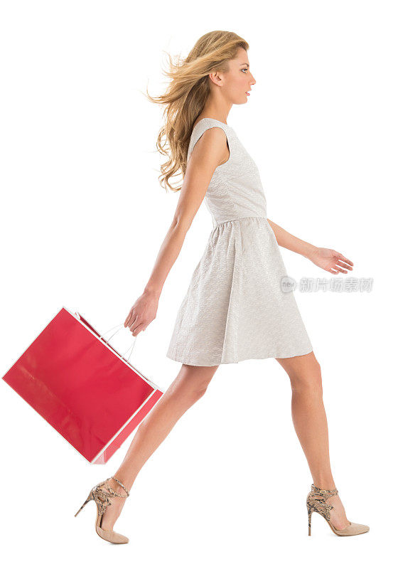 侧视图的女人走与购物袋