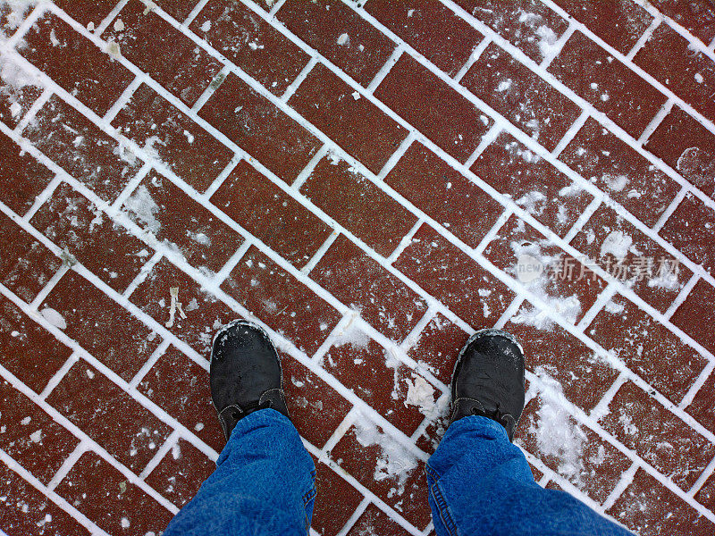 脚踩在铺着雪的鹅卵石上。