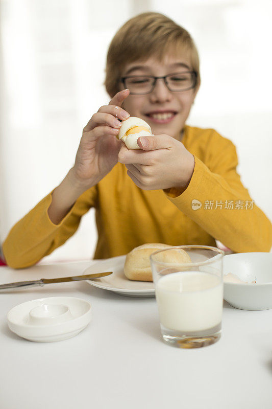 小男孩早餐吃鸡蛋和包子