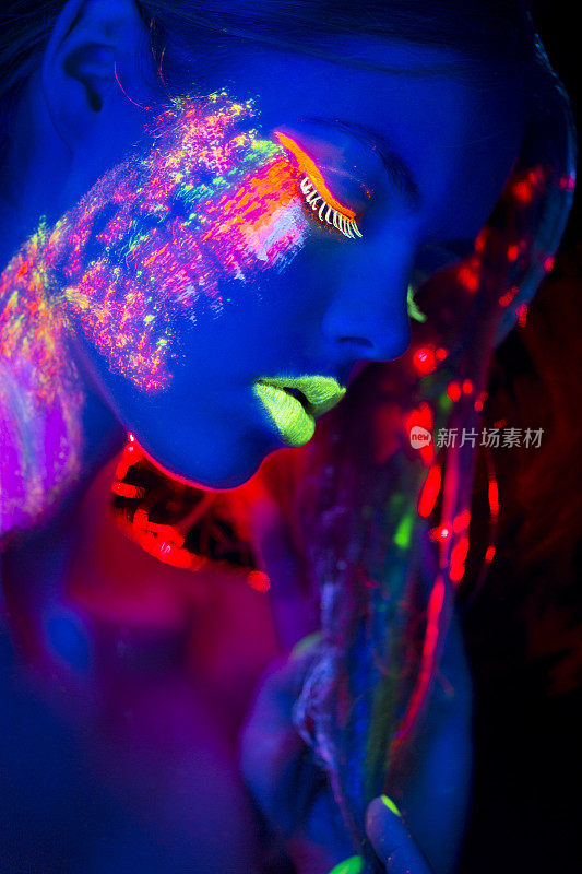 女人肖像与发光的多色化妆在霓虹灯