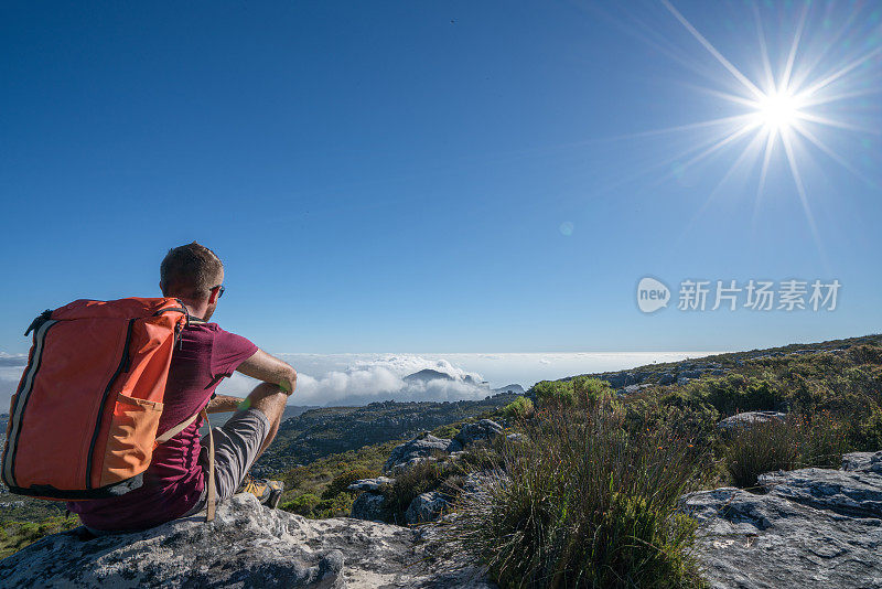 一个年轻人在开普敦山顶上看风景