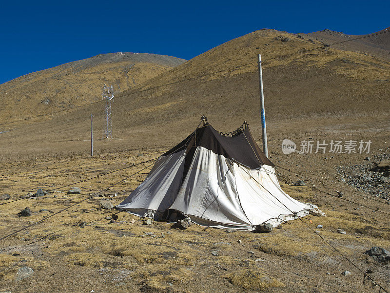 在长满草的山脉上的游牧帐篷。