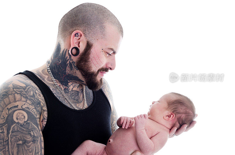 纹身的父亲凝视着新生的女儿。