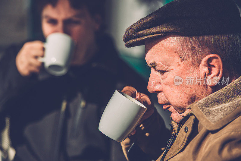 坐在轮椅上的老人和喝咖啡的孙子，欧洲