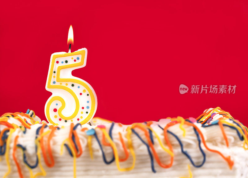 用5号蜡烛装饰生日蛋糕。红色的背景。