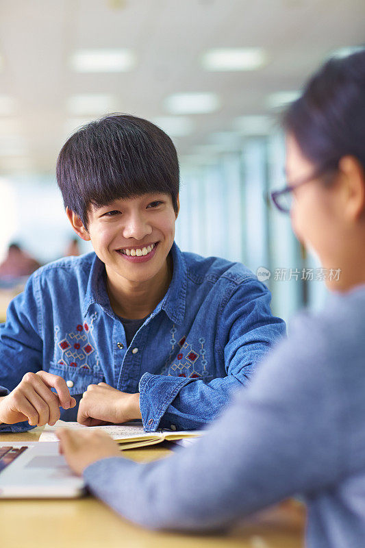 两个亚洲大学生在图书馆学习