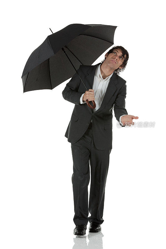 湿漉漉的商人撑着伞向上看