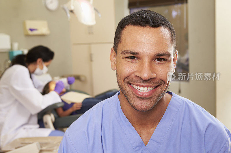 微笑的牙科护士在开放的牙科手术