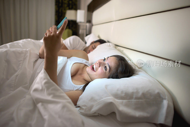 女人在床上用智能手机进行社交