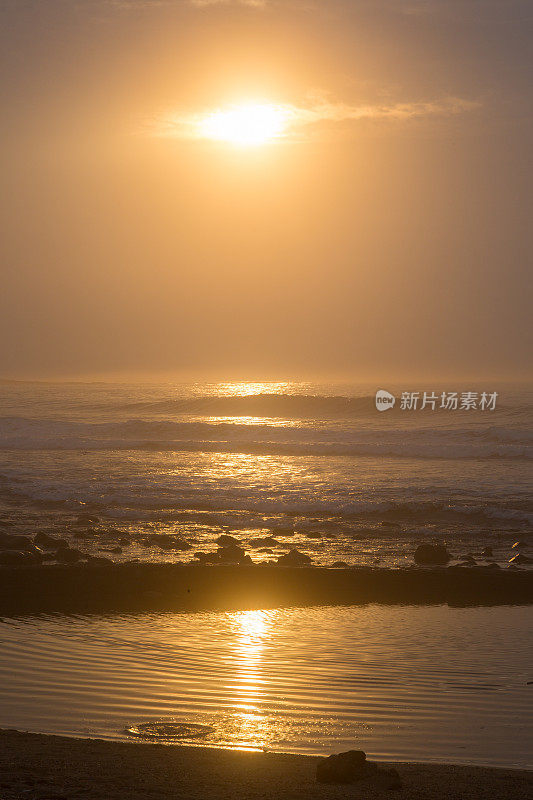 南非海岸潮汐池上方的日出