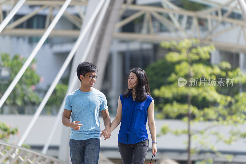 快乐的年轻亚洲夫妇在桥上滚动