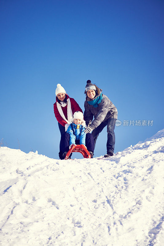 快乐的年轻夫妇在雪地里玩耍