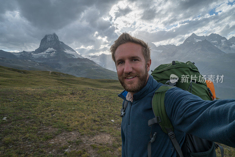 在瑞士马特洪峰徒步旅行的年轻男子的自拍照