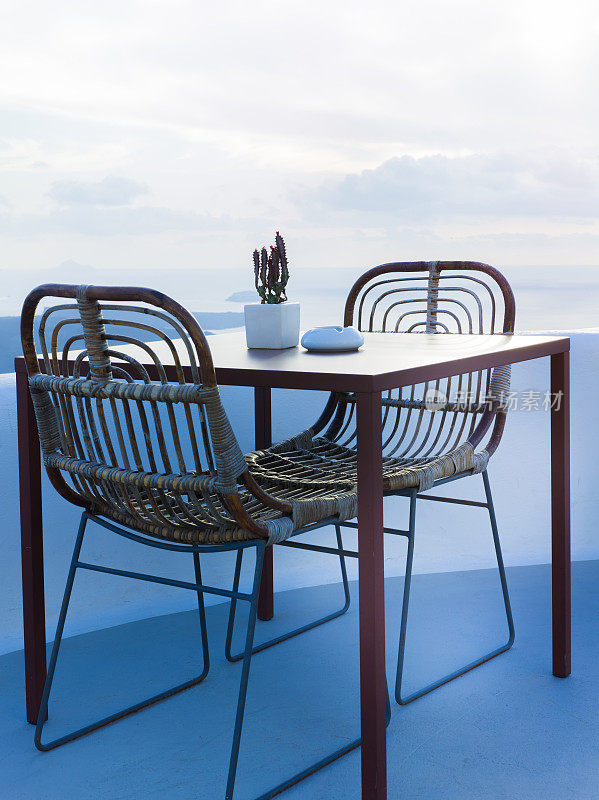 在美丽的阳台上有两把椅子和一张小桌子，可以看到美丽的海景