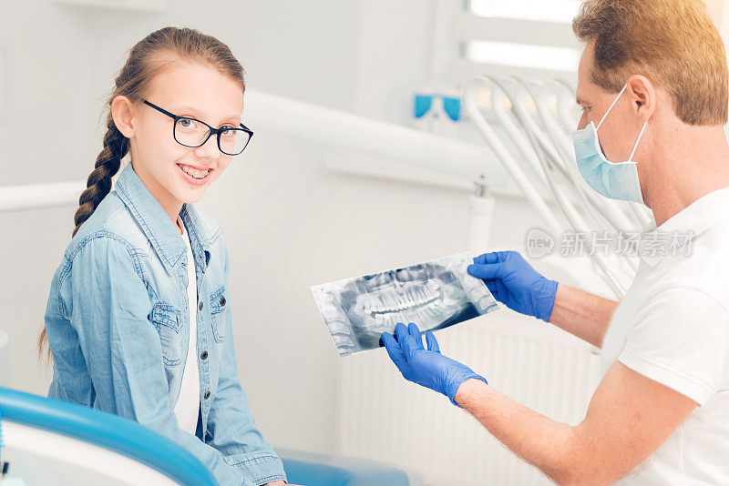 微笑的少女看镜头在牙科检查