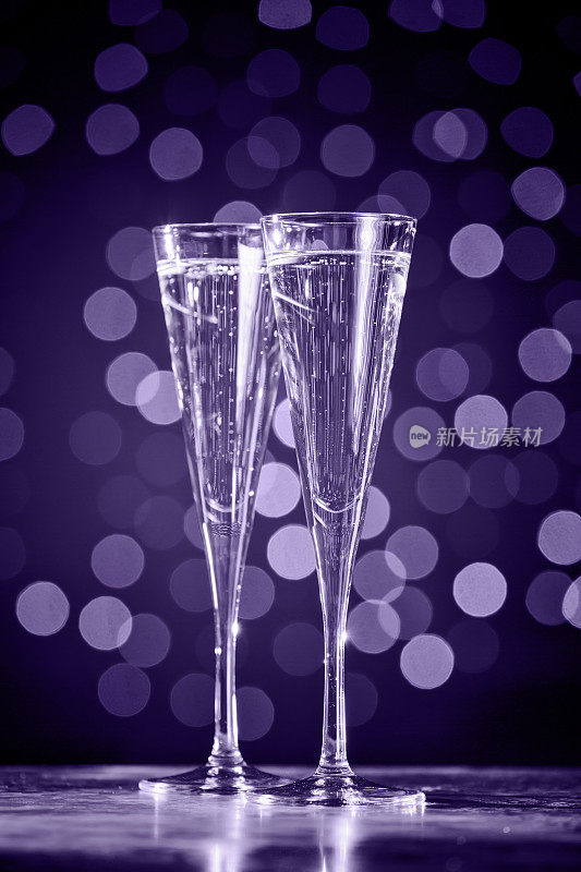 两杯香槟，背景是深焦。紫外光色调，2018年度流行色