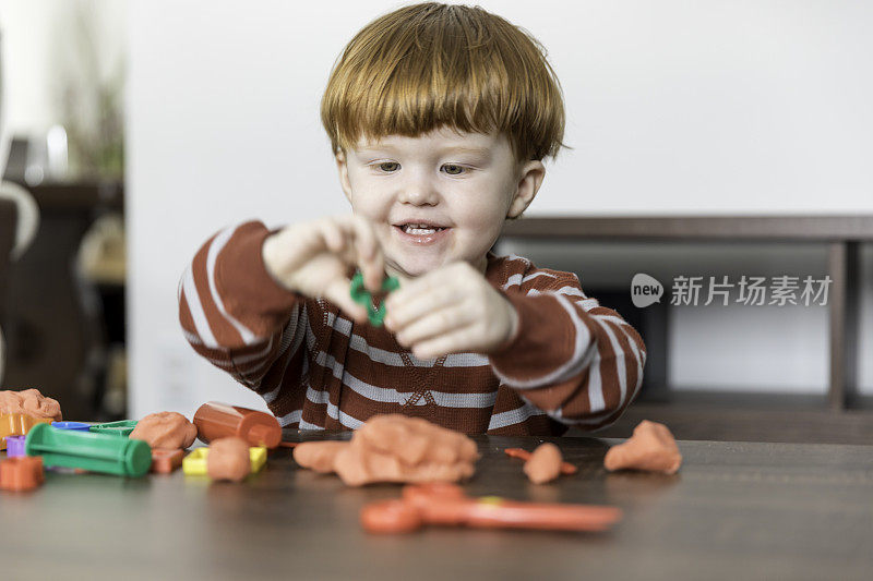 小男孩在玩彩色的儿童游戏粘土