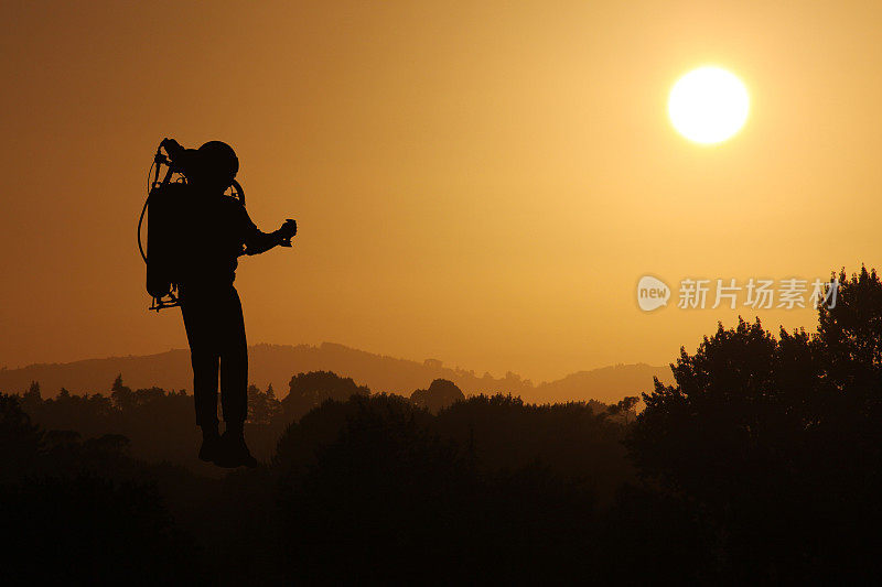 火箭人在日落中飞行天空的剪影