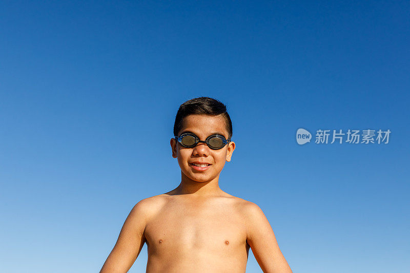 澳大利亚土著男孩与冲浪板在海滩上