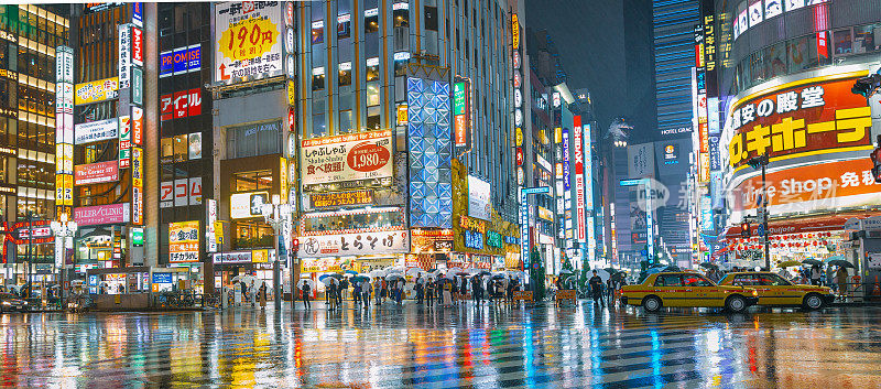 城市街道夜晚伴着人群而下着雨