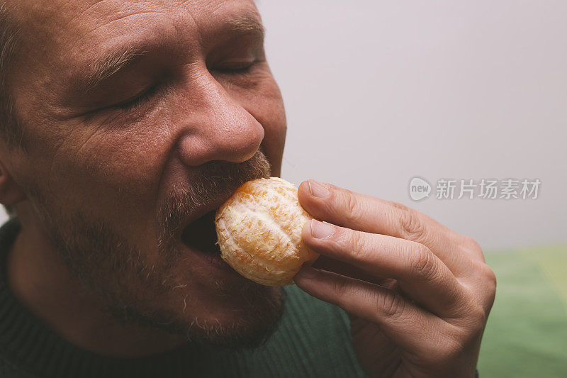 漂亮的成年男子喜欢吃一整个去皮的新鲜橙子