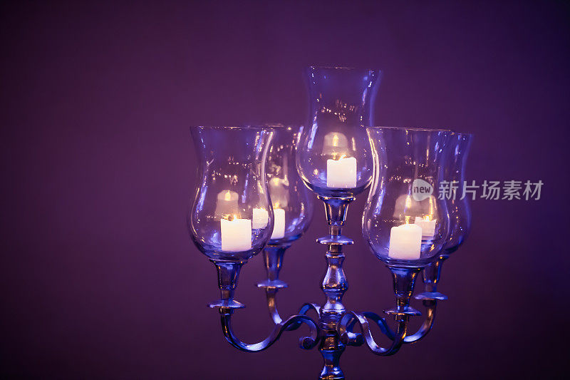 紫色穆迪神秘发光的蜡烛烛台，黑暗的背景