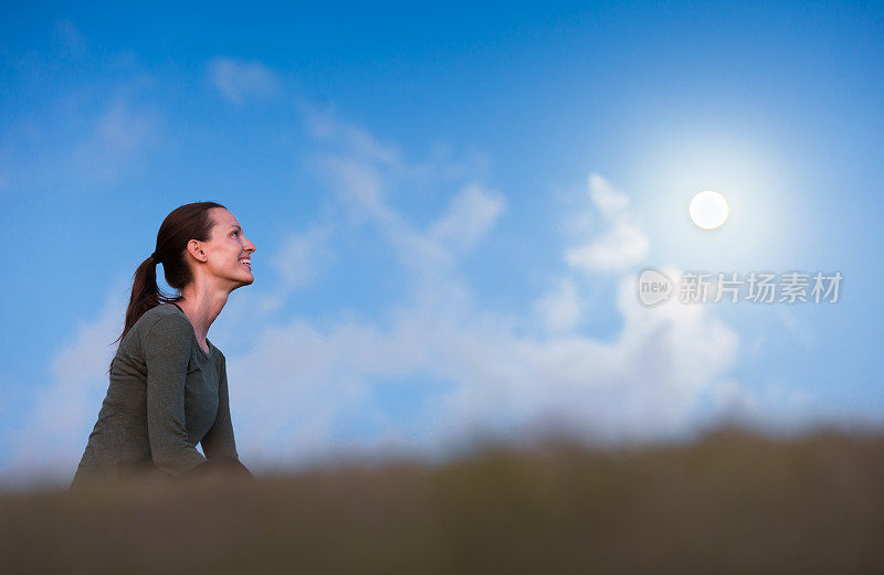 一个年轻女子抬头望着满月