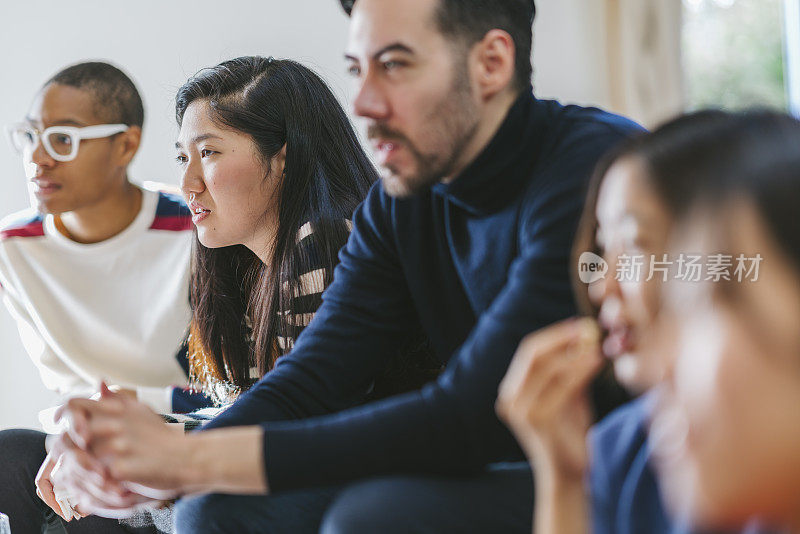 一群不同民族的朋友在家里喝着啤酒和披萨看电影