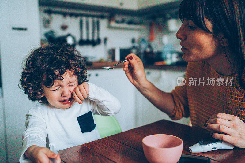 母亲给儿子喂糖浆