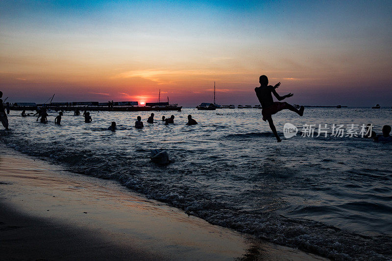 非洲男孩在桑给巴尔的夕阳下跳海