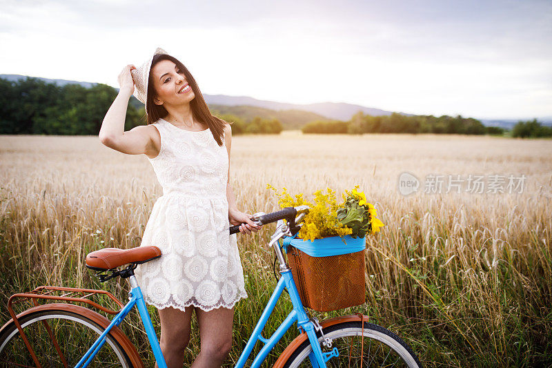 骑着自行车的女人在麦田里。