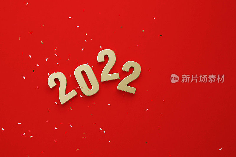 金色2022坐在红色背景下飘落的五彩纸屑下