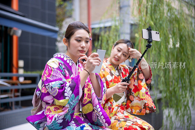 穿着和服的年轻女子在街上化妆