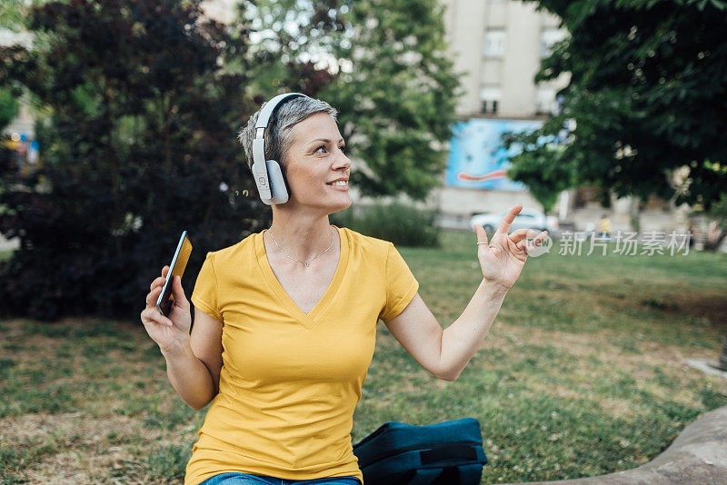 戴着耳机的女人在户外享受她最喜欢的音乐