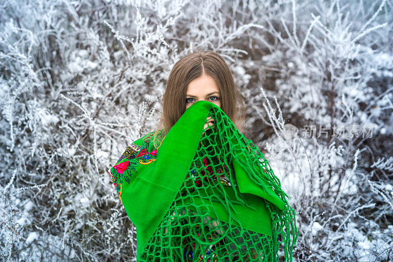 冬天森林里披着绿色披肩的女人。