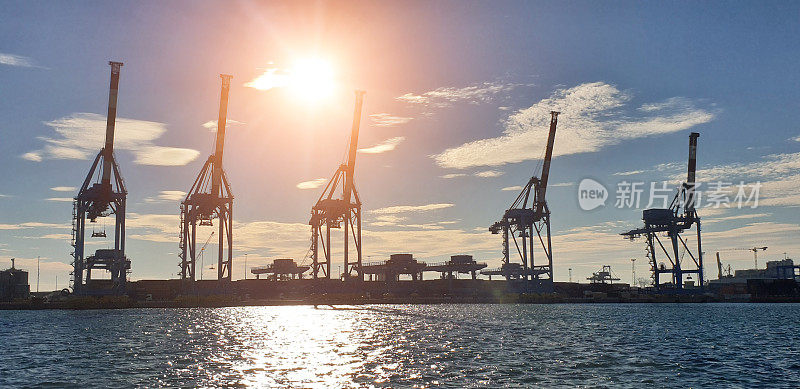 日落时分，热那亚海港码头上的龙门起重机