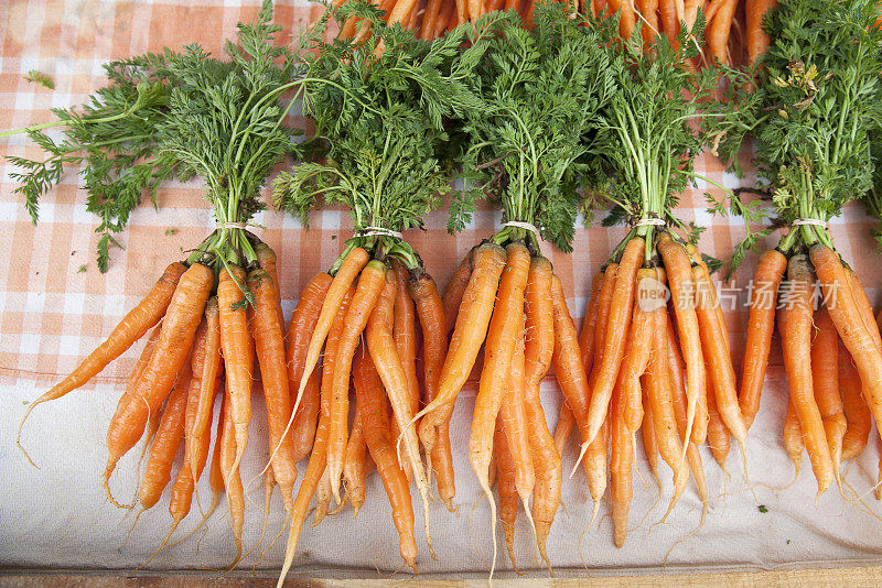 农贸市场上出售的几串新鲜胡萝卜