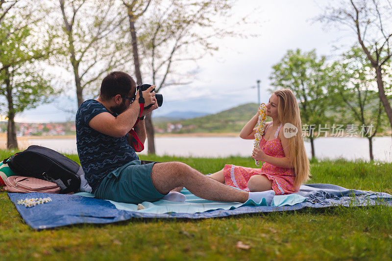 年轻浪漫的情侣在湖边放松的时候一起拍照