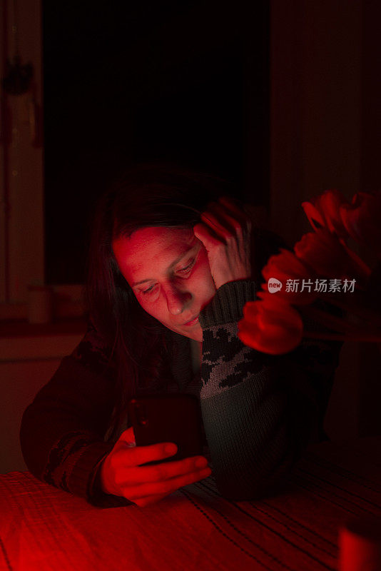 一个30多岁的孤独女人晚上在家打手机。