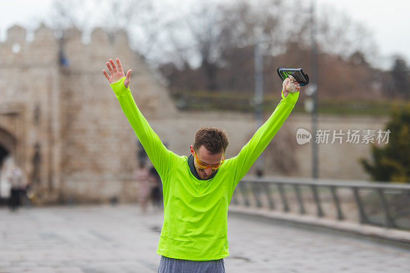 一个年轻男性跑步者穿着充满活力的跑步服庆祝他的新记录的肖像