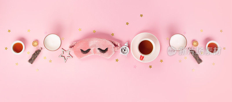 世界睡眠日在每年的3月举行。可爱的睡眠面具和闹钟粉红色粉彩背景，俯视图。