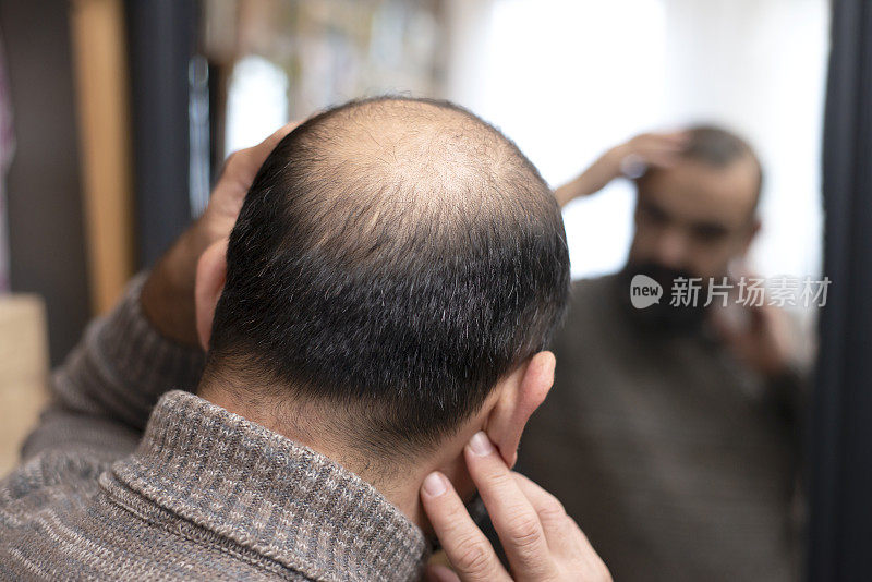 男人在镜子前检查头发