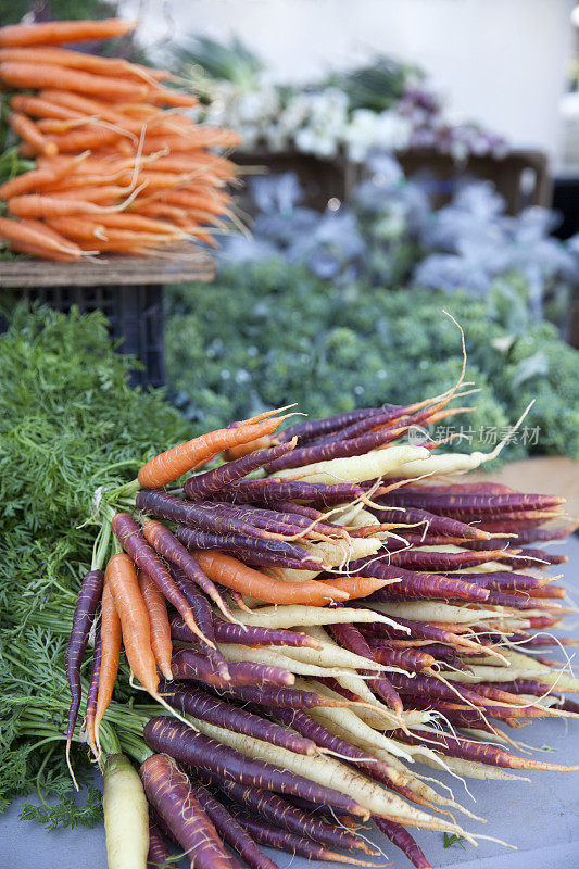 在农贸市场出售的新鲜胡萝卜和其他蔬菜
