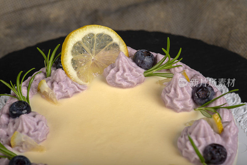 用生奶油和迷迭香装饰的自制蓝莓芝士蛋糕