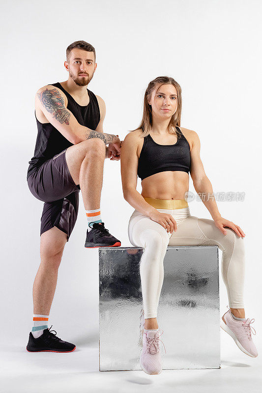 摄影棚中男女合影。健身理念，锻炼肌肉。专业运动员，适合摄影。两个人在做运动