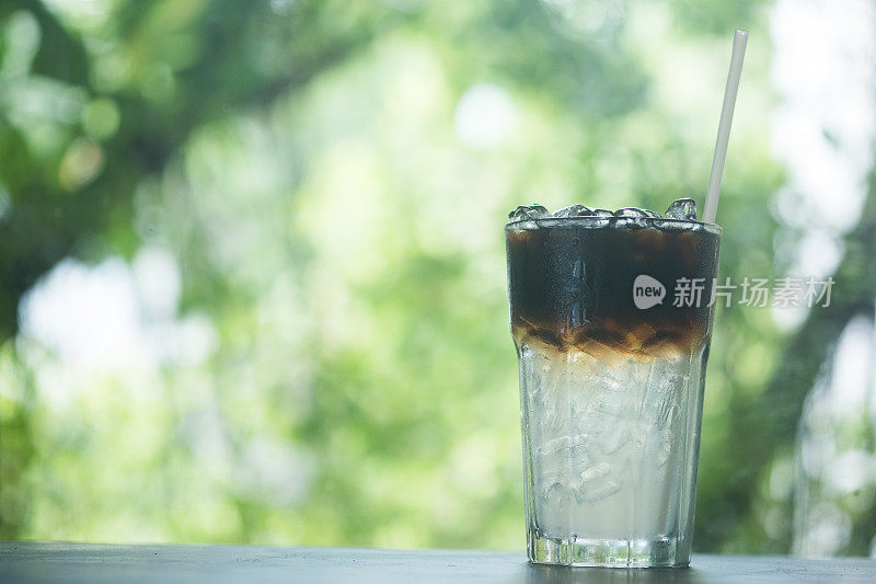 一杯冰美式咖啡，有两层，咖啡和水。