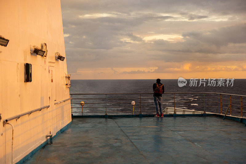 度假期间，男子在游轮上看海景