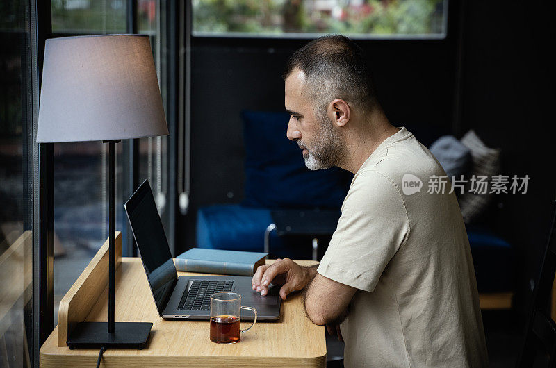 一个随意的自由企业家在笔记本电脑上工作的肖像