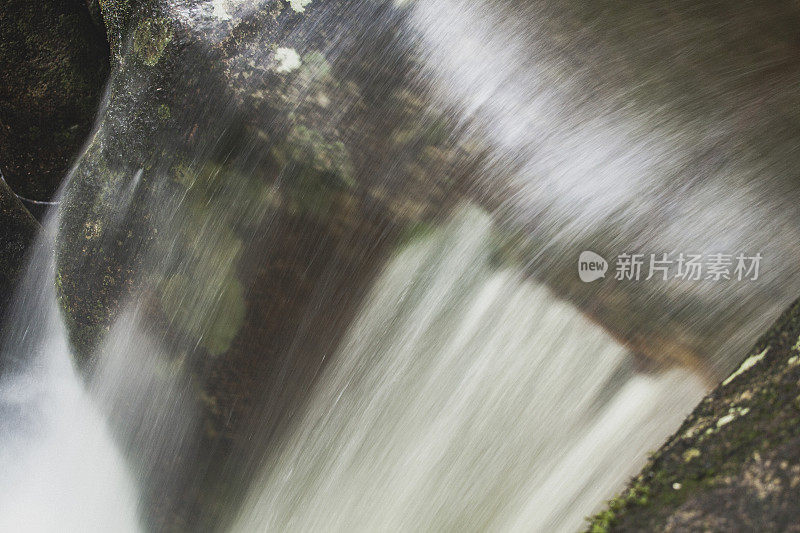 近距离的瀑布流经岩石流入淡水